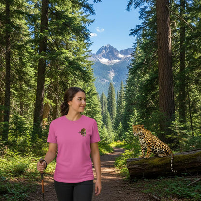 Woman wearing a pink t-shirt with a jaguar print, hiking on a forest trail with mountains in the background.